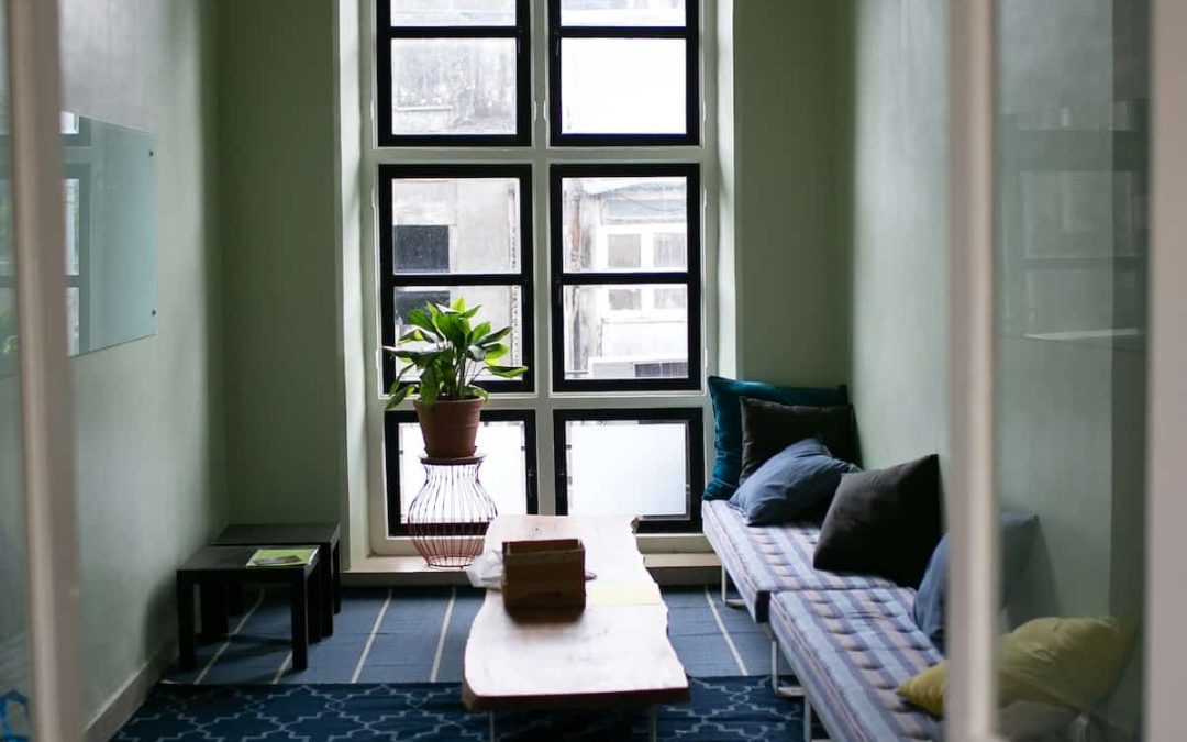 Quiet therapy office with a window seat, cushioned bench, and coffee table
