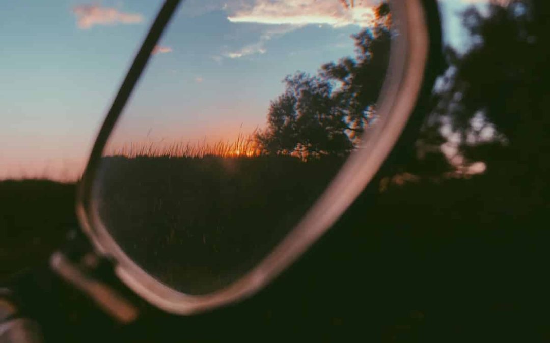 Sunset sky and trees reflected in the lens of a pair of eyeglasses