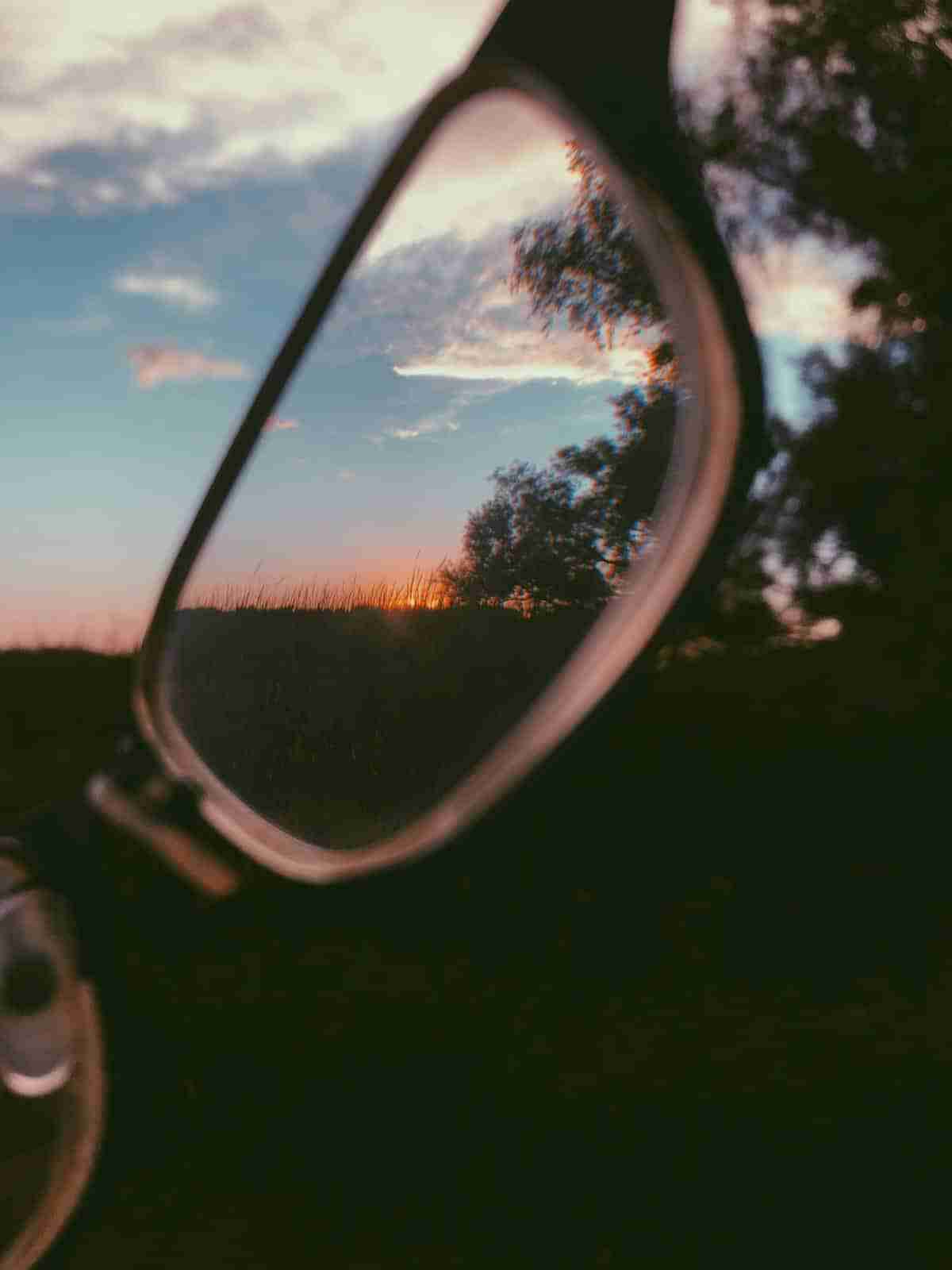 Sunset sky and trees reflected in the lens of a pair of eyeglasses