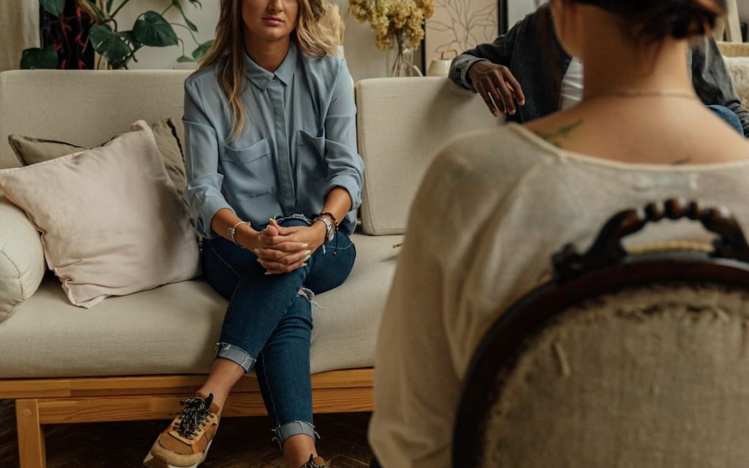 Woman talking with a therapist while seated on a couch in a cozy therapy office
