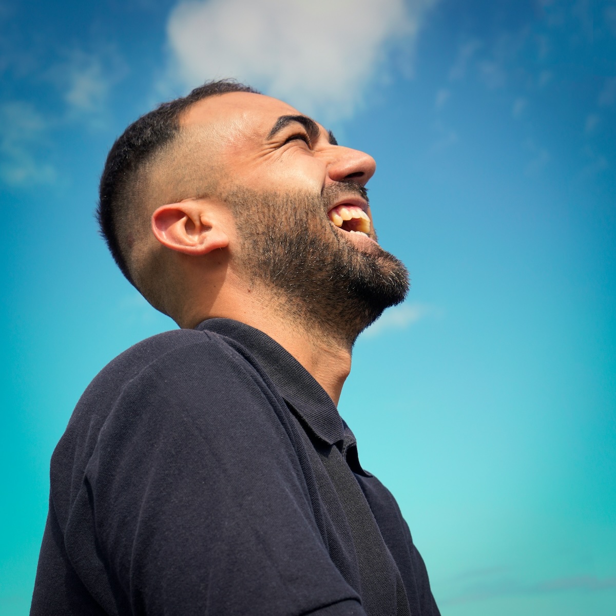 Man standing outdoors in quiet reflection, symbolizing happiness through clarity, self-control, and emotional balance
